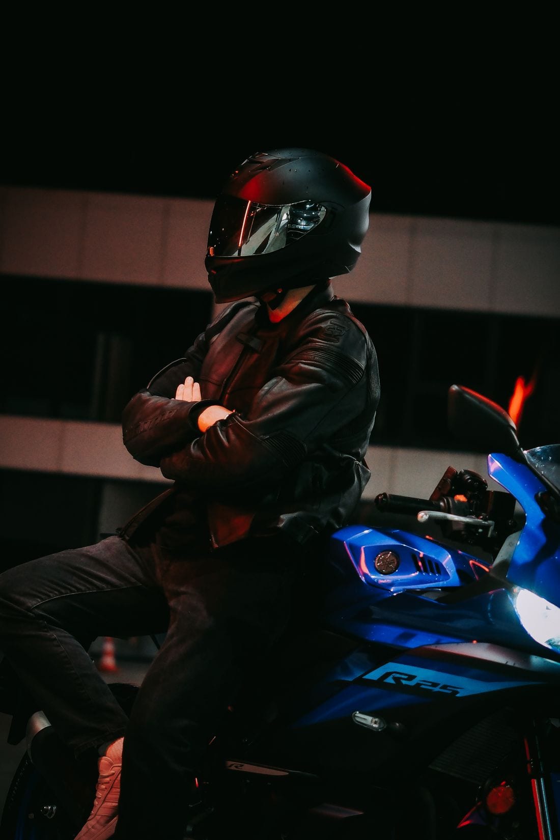 Motociclista de capacete preto visto de perto à noite