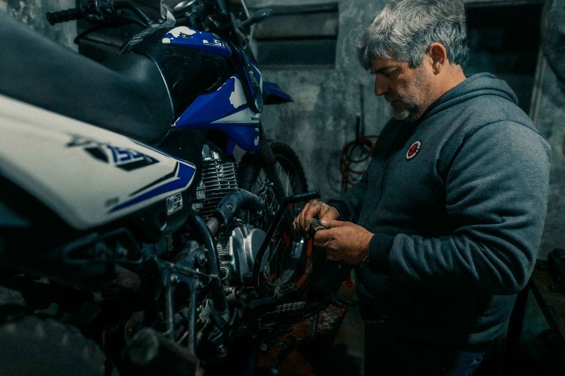 Mecânico trabalhando no motor de uma moto na garagem