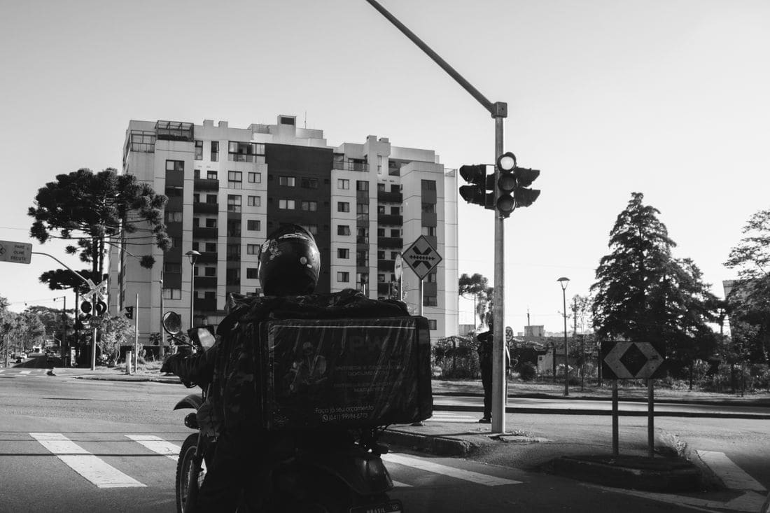 Motociclista em rua da cidade, foto em preto e branco